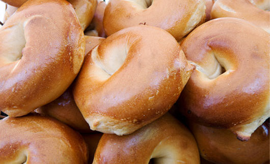 Multiple plain bagels in a pile.